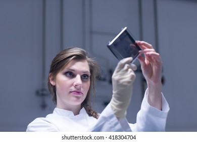 Young Female Scientist Examining Microscopy Slide In Lab