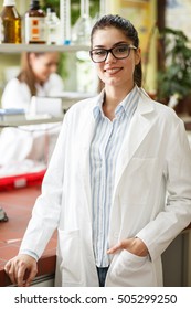 Young Female Scientist Standing In Her Lab.