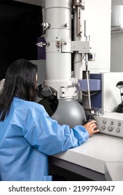 Young Female Scientist Working At The Laboratory With An Electron Microscope