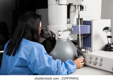 Young Female Scientist Working At The Laboratory With An Electron Microscope