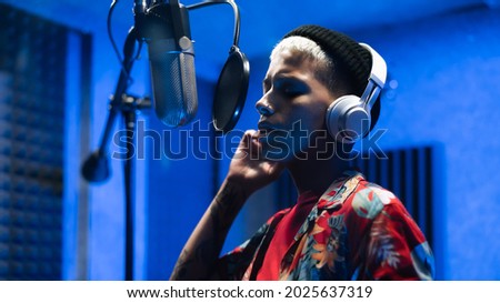 Young female singer recording a new song album inside music production studio  