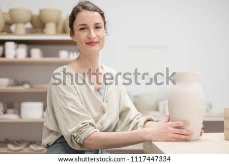 Similar – Woman in work wear in her workshop by table with handmade items