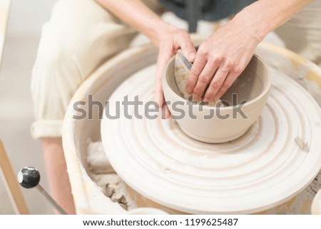 Similar – Young female sitting by table and making clay or ceramic mug