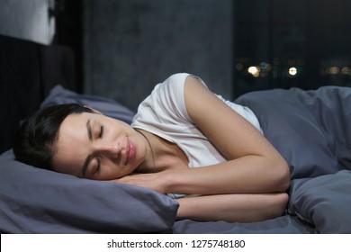 Young female sleeping peacefully in her bedroom at night, relaxing - Shutterstock ID 1275748180