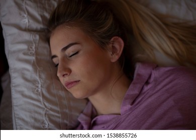 Young female sleeping soundly in bed 