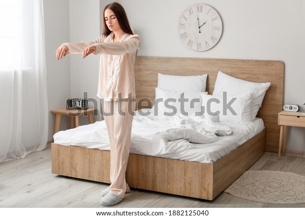 Young female sleepwalker in\
bedroom