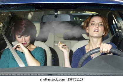 Young Female Smoking While Driving Inside The Car