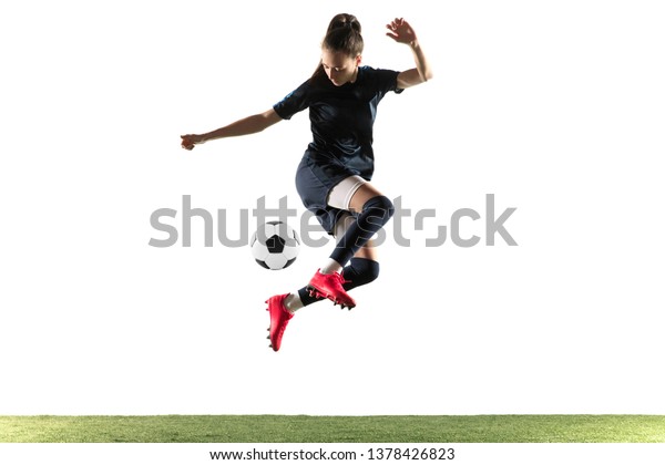 白い背景にジャンプで スポール着に長い髪の毛を持つ若い女性サッカーやサッカー選手 そしてボールを蹴り飛ばしてゴールをする 健康的なライフスタイル プロのスポーツ 趣味のコンセプト の写真素材 今すぐ編集