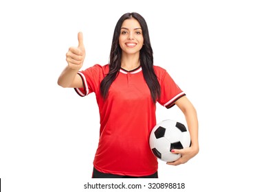 Young female soccer player holding a ball and giving a thumb up isolated on white background - Powered by Shutterstock