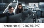 Young Female Software Developer Working on Computer Together with a Friendly Colleagues. Female Asking Advice from a Manager About a Solution for Their Collaborative Tech Project
