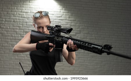 a young female soldier poses with an automatic rifle with a telescopic sight in a shooting range