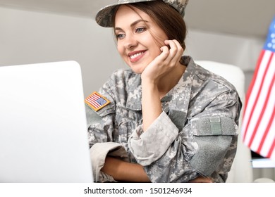 Young Female Soldier Working With Laptop In Headquarters Building