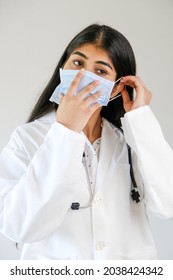 A Young Female South Asian Doctor From India Putting A Mask