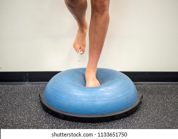 Young Female Standing On A Bosu Ball For A Workout 