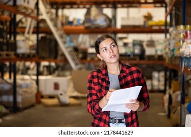 Young Female Stock Clerk Checking Warehouse Inventory