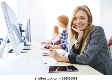 Young Female Student Feeling Ready To Write Exam Testing And Making Individual Tasks Using Technology Computer And Tablet Connected To Global Network While Smiling In University Coworking Space