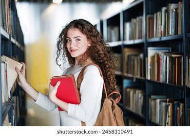 Young female student in library, looking for books, preparing for final exam. - Powered by Shutterstock