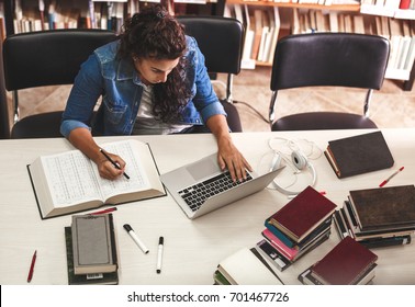 Young Female Student Study In The School  Library.She Using Laptop And Learning Online.