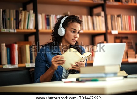 Young female student study in the school  library.She using laptop and learning online.