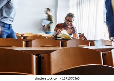 Young Female Student Taking A Test In University Classroom.	