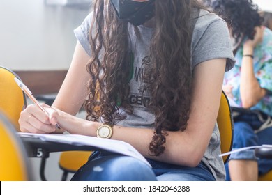 Young Female Student Wearing A Mask And Taking An Important Exam At School. 