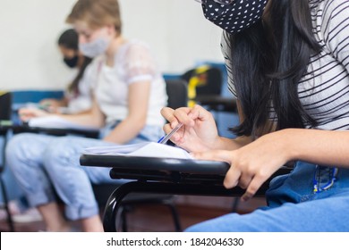 Young Female Student Wearing A Mask And Taking An Important Exam At School. 