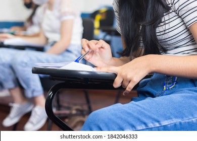 Young Female Student Wearing A Mask And Taking An Important Exam At School. 