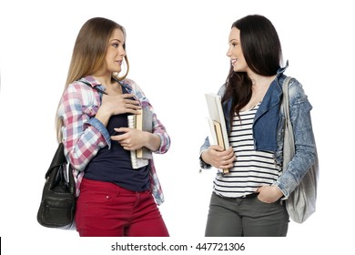 Young female students standing with books and bags, isolated on white