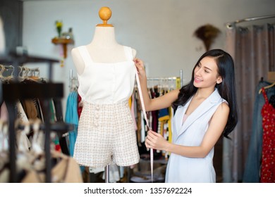 Young female stylist measuring dress on mannequin with tape.Woman fashion designer working in studio - Powered by Shutterstock