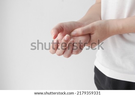 Young female suffering from pain in hands and massaging her painful hands. hurt include carpal tunnel syndrome, fractures, arthritis or trigger finger, Peripheral neuropathy.