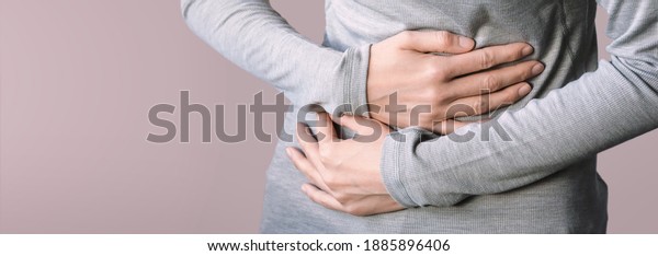 Young female\
suffering from stomach - pain include menstruation pain, gastritis,\
stomach ulcer, food poisoning, diarrhea or IBS. Close up woman\
holding belly, feeling discomfort.\
