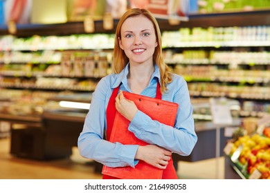 Young female supermarket employee holding a clipboard - Powered by Shutterstock