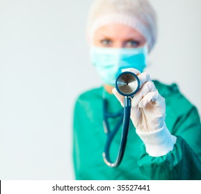 Young Female Suregon holding stethoscope outwards with focus on the stethoscope