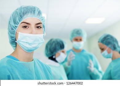 Young Female Surgeon With Medical Team In Back Before Surgery