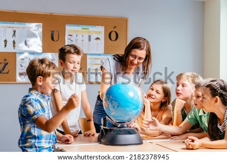 Young female teacher showing globe to children. Make the world a better place. Where will we go to travel next time? Stock photo © 