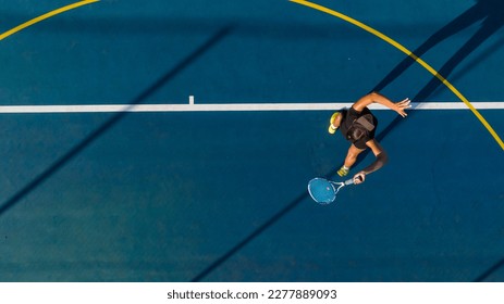 a young female tennis player in action on a brand-new court. This photo was captured with a drone to give a unique perspective on the game. Perfect for sports publications, athletic advertisements, an - Powered by Shutterstock