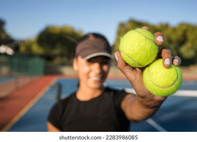 A young female tennis player is in action on a brand-new tennis court. This photo features a stunning backlight and was taken with a wide-angle lens to bring you closer to the action.