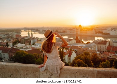 Young female tourist enjoys the view of the city at sunset. back view.  Lifestyle, travel, tourism, nature, active life.