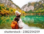 Young female tourist looking at beautiful autumn scenery landscape at jiuzhaigou national park in Sichuan, China