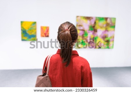 Young female tourist looking gallery exhibition. Art, Painting, photography, Inspiration and museum concept