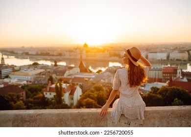 Young female tourist  looking at panoramic view of  the city at sunset. Lifestyle, travel, tourism, nature, active life.