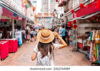 Young female tourist walking in Chinatown street market in Singapore