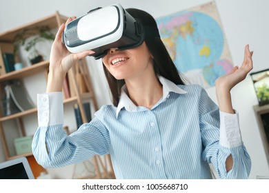 Young Female Travel Agent Consultant In Tour Agency Playing Virtual Reality Headset