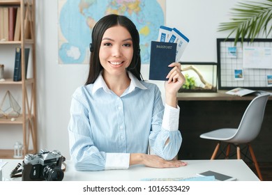 Young Female Travel Agent Consultant In Tour Agency Showing Documents