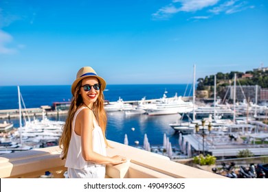 Young female traveler enjoying great view on the harbor with yachts in Monte Carlo in Monaco