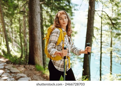 Young female traveler with hiking poles and a bright backpack. Healthy lifestyle eco tourism. - Powered by Shutterstock