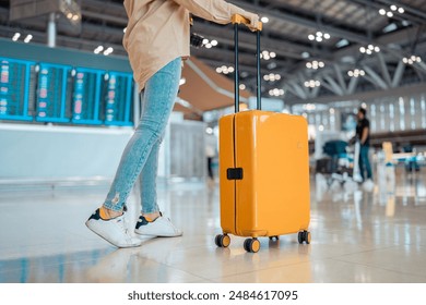 Young female traveler passenger walking with a yellow suitcase at the modern Airport Terminal, Back view of woman on her way to flight boarding gate, Ready for travel or vacation journey