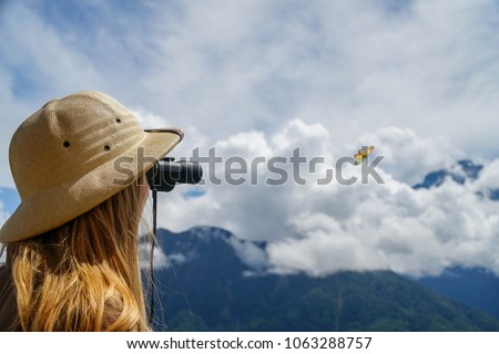 Young Female Traveler Watching with Binoculars at Mountain. Active Tourism