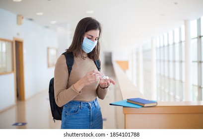 Young Female University Student Wearing Mask And Using Hand Sanitizer Gel During Covid-19