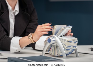 Young Female Using Business Card Roller Deck In An Office